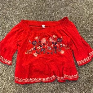 a red floral top that is off the shoulder